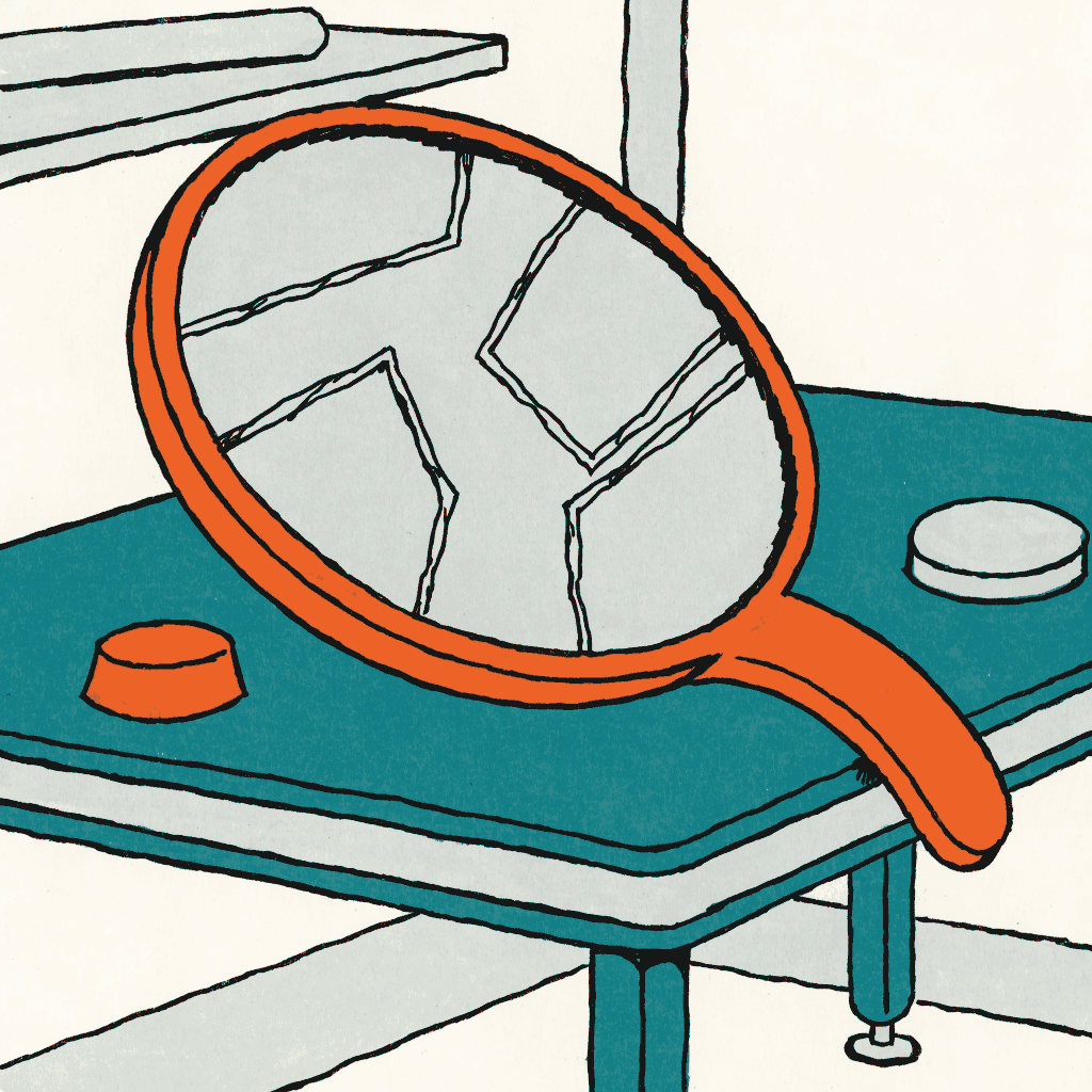 A cracked hand mirror lying face up on a dressing table