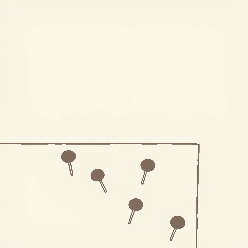 A corkboard with four pushpins and no photographs, string or notes between them