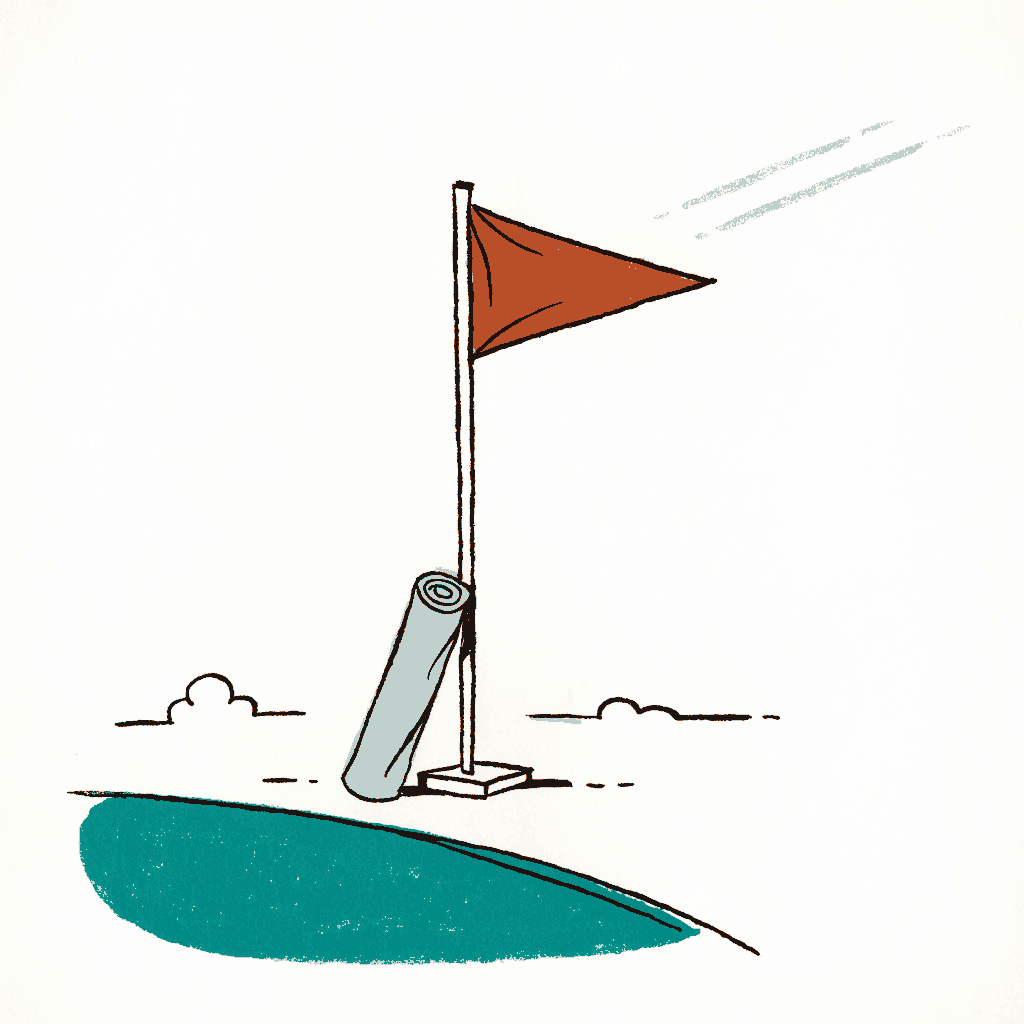 A football pitch corner flag with a prayer mat folded beside it
